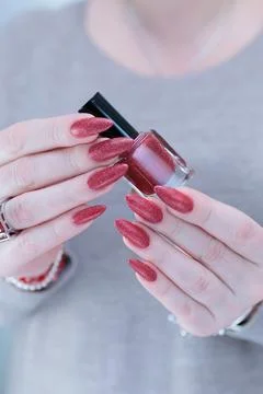 Hands with long nails and dark red nail polish 스톡 사진