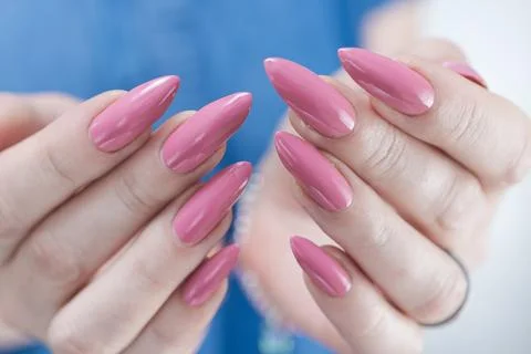 Hands with long nails and a light pink color nail polish Foto stock