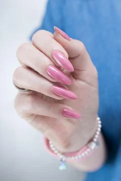 Hands with long nails and a light pink color nail polish Stock Photos