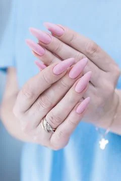 Hands with long nails and a light pink color nail polish 스톡 사진