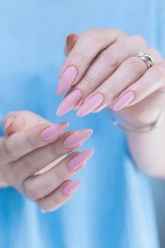 Hands with long nails and a light pink color nail polish Stock Photos