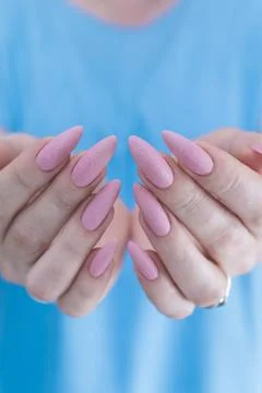 Hands with long nails and a light pink color nail polish Stock Photos