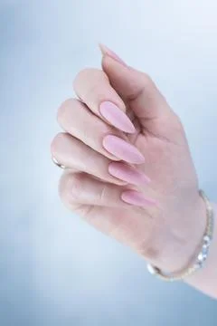 Hands with long nails and a light pink color nail polish 库存照片