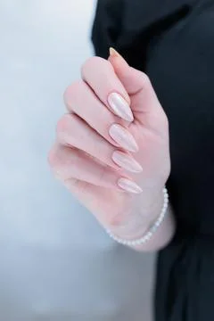 Hands with long nails and a light pink color nail polish Stock Photos