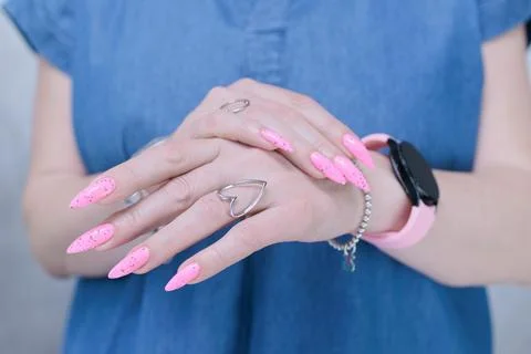 Hands with long nails and neon light pink nail polish Stock Photos
