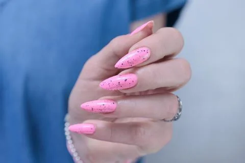 Hands with long nails and neon light pink nail polish Stock-Fotos