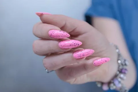 Hands with long nails and neon light pink nail polish Foto stock