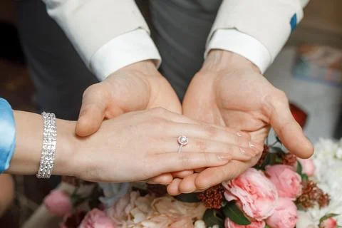 Hands of lovers on a bouquet Stock Photos