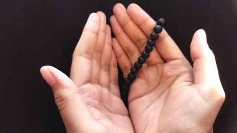 Hands Lowering After Prayer with Tasbih Beads on Dark Background Stock Footage 325663040