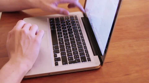 Hands on an Macbook on a wooden table Stock Footage 40359583