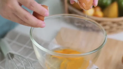 Hands made cracked fresh egg yolks dripping into the bowl. Homemade food Stock Footage 242227766