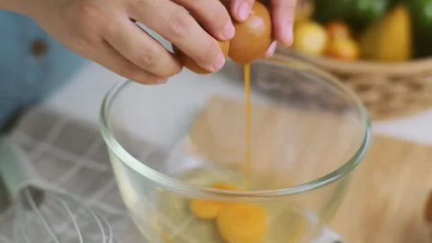 Hands made cracked fresh egg yolks dripping into the bowl. Homemade food Stock Footage 242227822