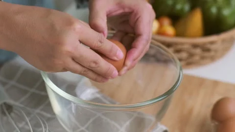 Hands made cracked fresh egg yolks dripping into the bowl. Homemade food Stock Footage 242228023