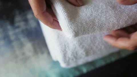 Hands maid putting stack of fresh clean white bath towels on bed. Stock Footage 218624282