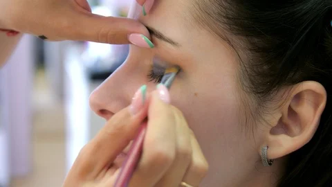 Hands make-up artist applied makeup on the face of a young woman. Girl doing eye Vidéo 107181072