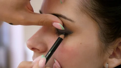 Hands make-up artist applied makeup on the face of a young woman. Girl doing eye Vidéo 107181558