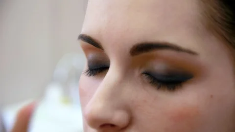 Hands make-up artist applied makeup on the face of a young woman. Girl doing eye Vidéo 107181727