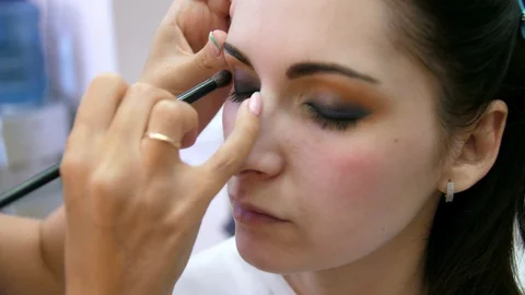 Hands make-up artist applied makeup on the face of a young woman. Girl doing eye Vidéo 107182205
