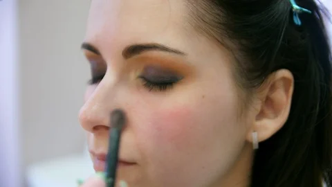 Hands make-up artist applied makeup on the face of a young woman. Girl doing eye Vidéo 107182487