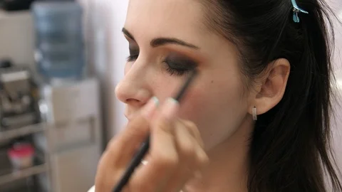 Hands make-up artist applied makeup on the face of a young woman. Girl doing eye Video stock 107278098