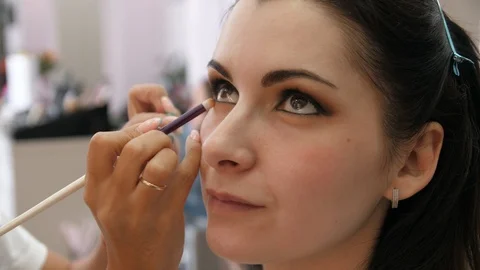 Hands make-up artist applied makeup on the face of a young woman. Girl doing eye Stock-Footage 107278508