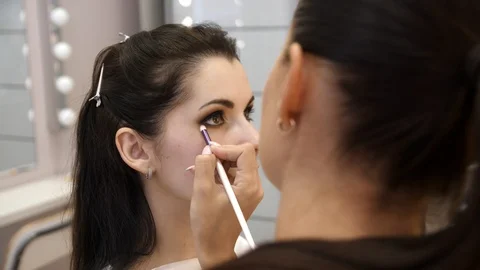 Hands make-up artist applied makeup on the face of a young woman. Girl doing eye Video stock 107278889
