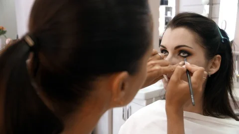 Hands make-up artist applied makeup on the face of a young woman. Girl doing eye Stock Footage 107279293