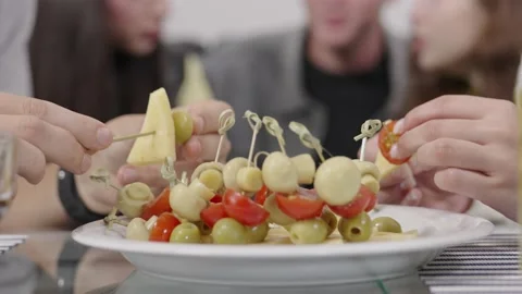 Hands make canape from olives, cherry tomato, cheese and champignons. Stock Footage 221568728