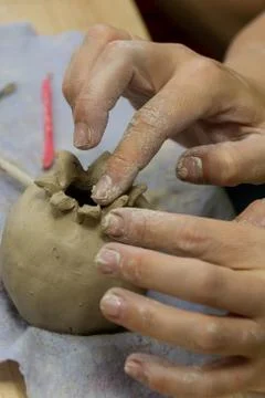 Hands make crafts from clay. Creativity. Transformation of clay into crafts. Stock Photos