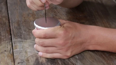 Hands make holes in the foil on the hookah bowl Stock Footage 119555337