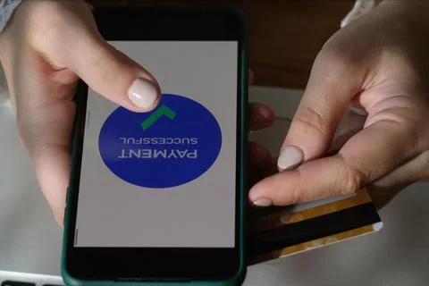 Hands make money transfer using smartphone and plastic bank card Stock Photos