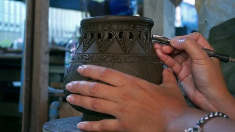 Hands make potter inflicts a decorative pattern on earthenware Stock Footage 126227726