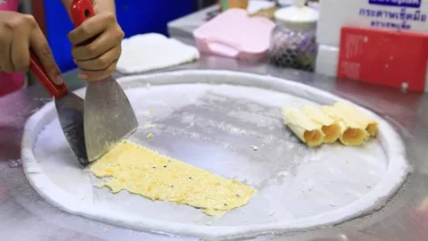 Hands make roll ice cream for an outdoor party. a refreshing sweet dish made fro Stock Footage 229563062