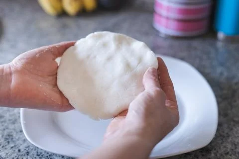 Hands making arepas in the kitchen. Latin food. Stock Photos