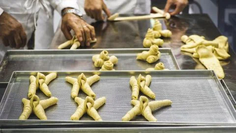 Hands making bread in baker factory horn shape Stock Photos