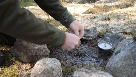 Hands Making Fire Outdoors with Compass and Rocks Vidéo 333403511