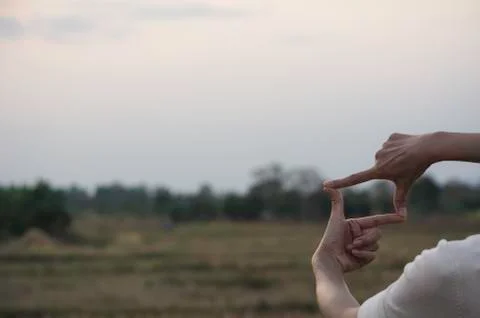 Hands making frame with sunset. Close up of woman hands making frame gesture. Stock Photos
