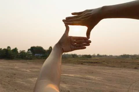 Hands making frame with sunset. Close up of woman hands making frame gesture. Stock Photos