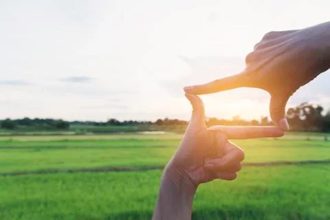 Hands making frame with sunset. Close up of woman hands making frame gesture. Stock Photos