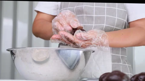 Hands making homemade cocoa balls stuffed with dark chocolate cubes at home. Stockbeeldmateriaal 177441192