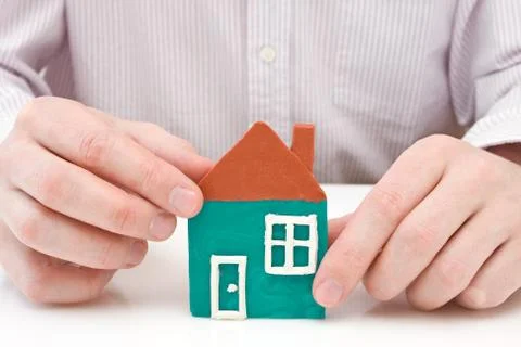 Hands making house from plasticine Stock Photos