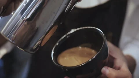 Hands making latte art coffee. Ideal morning routine concept with coffee latte. 動画素材 334648207