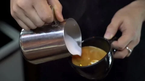 Hands making latte art coffee. Ideal morning routine concept with coffee latte. 動画素材 334648271