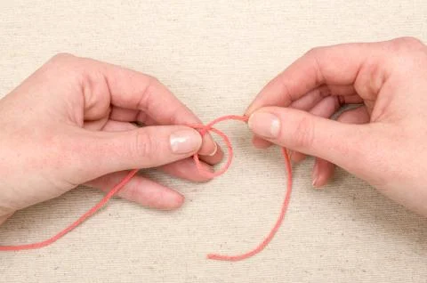 Hands Making a Loop with Orange Yarn Stock Photos