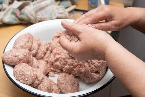 Hands making minced meat cutlets. Preparing meatballs with raw mincemeat Stock Photos