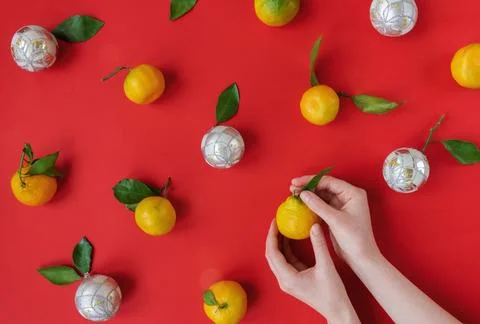 Hands making natural organic christmas toys from tangerines with green leaves Stock Photos