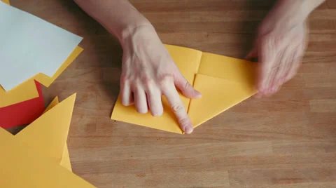 Hands making origami ship with yellow paper Stock Footage 35104365