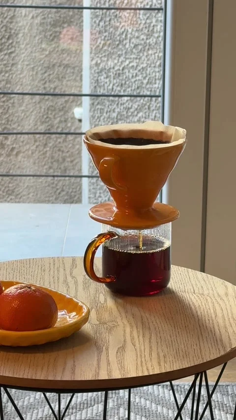 Hands making pour over coffee with ceramic dripper and paper filter 스톡 동영상 330860673