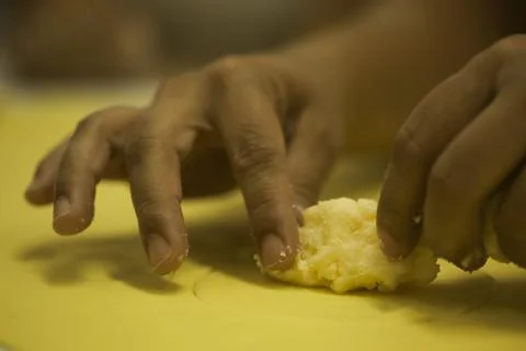 Hands making Raw and dry capeletti pasta on kitchen table Stock Photos