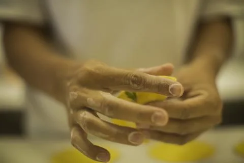 Hands making Raw and dry capeletti pasta on kitchen table Stock Photos